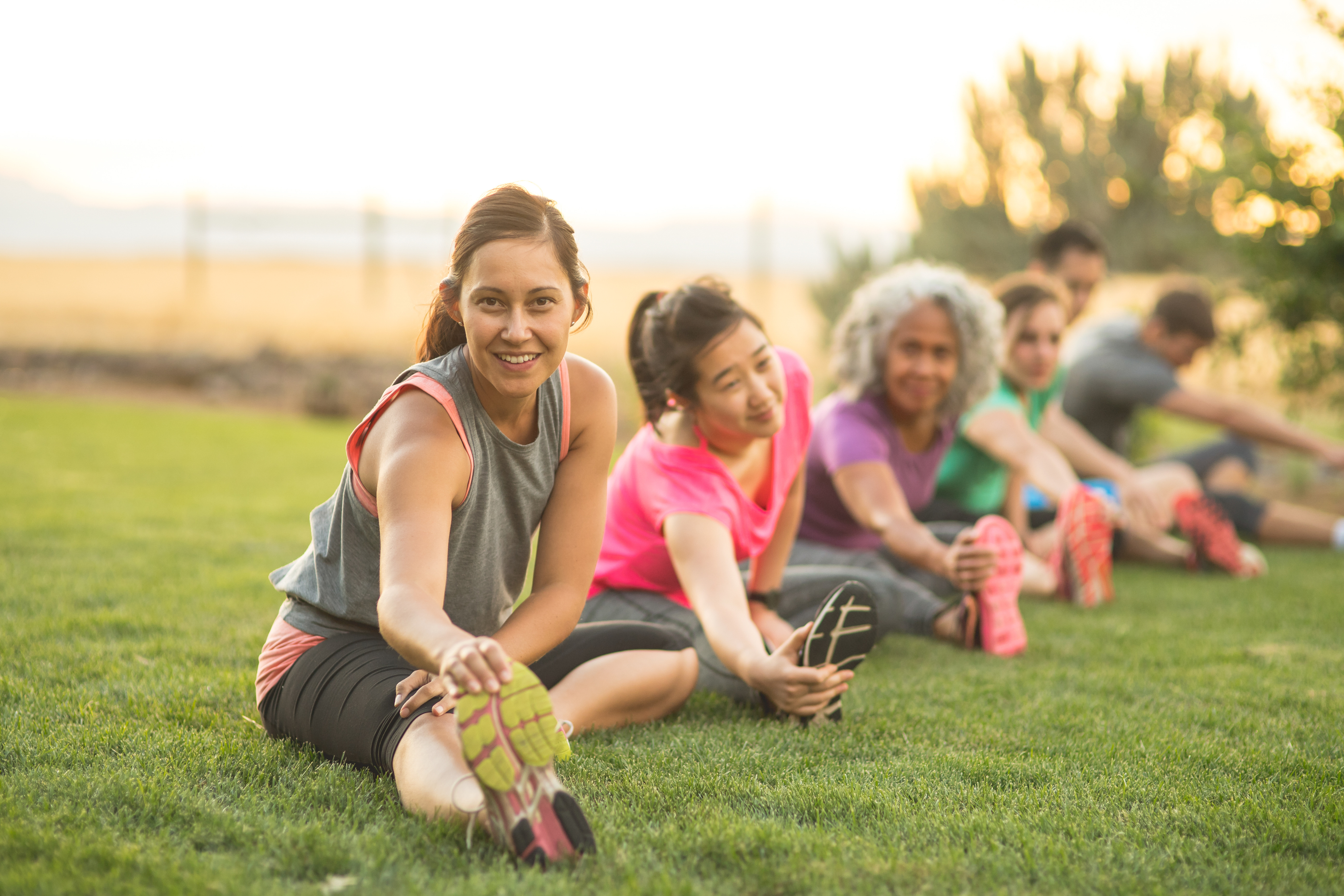Fitness enthusiasts stretch in the park